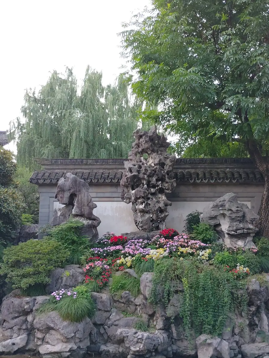 A rockery wall in Yu Garden with flowering plants